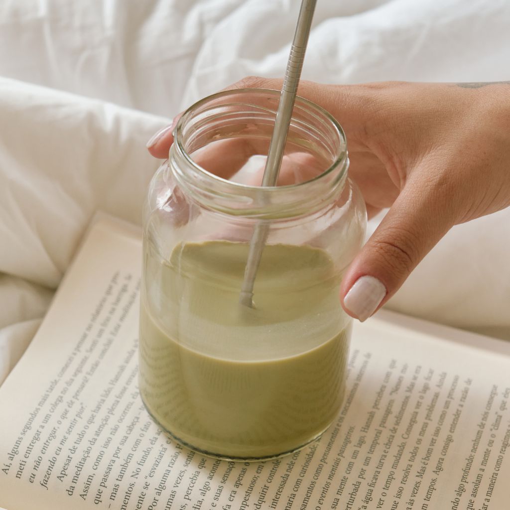 Smoothie sitting on book with hand around it