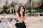 Nuala sitting on a rock by a rocky shoreline