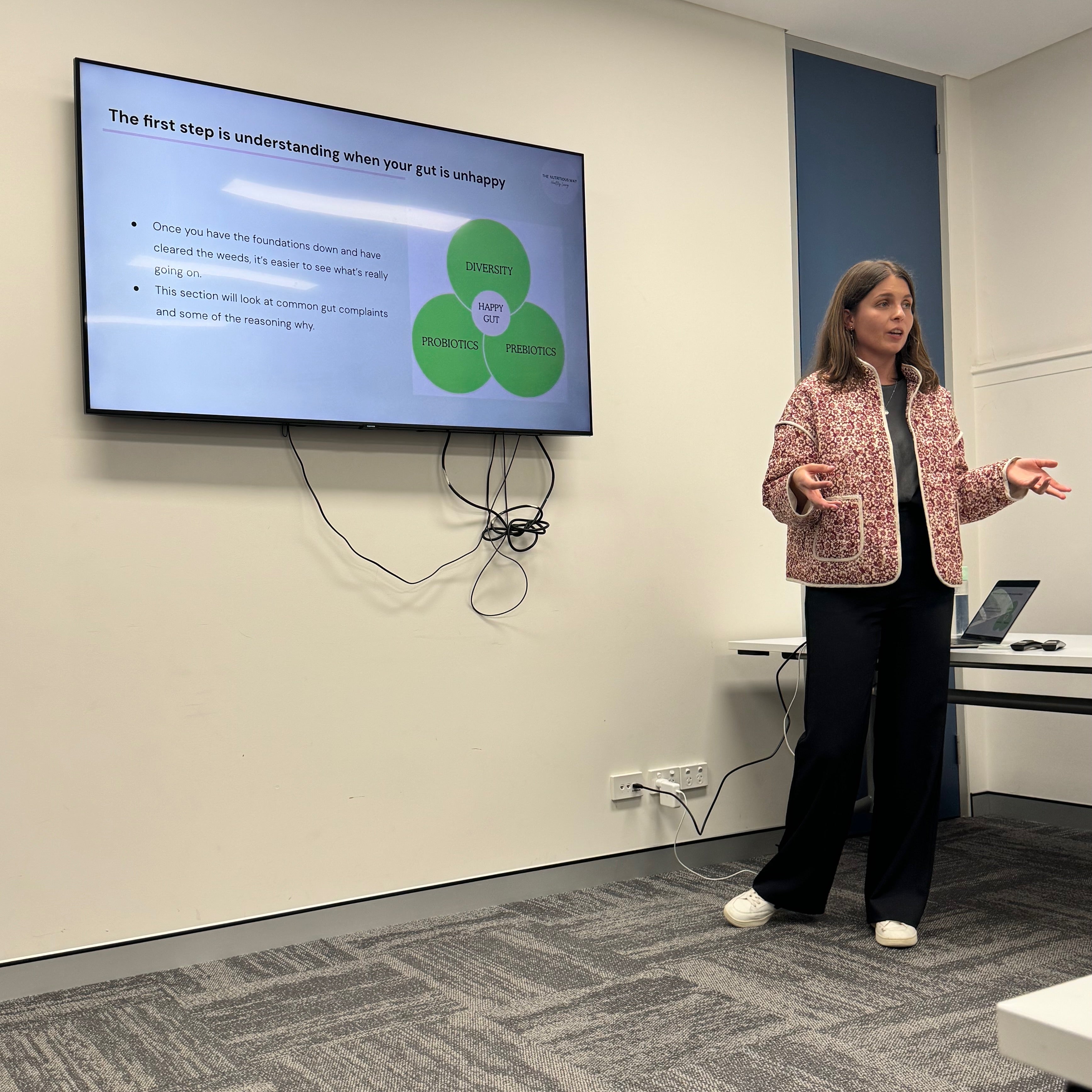 Nuala giving a gut presentation in front of a screen with a diagram
